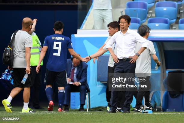 Shinji Okazaki of Japan leaves the pitch being injured as manager Akira Nishino looks on during the 2018 FIFA World Cup Russia group H match between...
