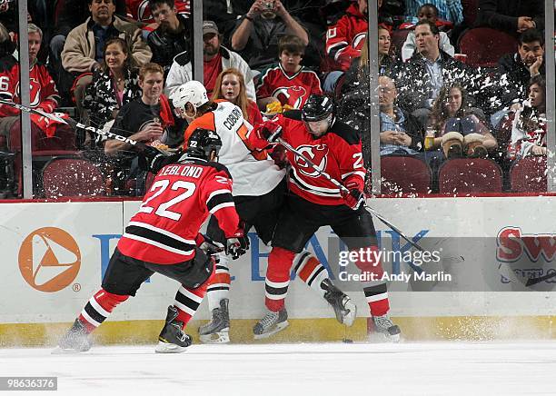 Braydon Coburn of the Philadelphia Flyers is sandwiched between Rob Niedermayer and Pierre-Luc Letourneau-Leblond of the New Jersey Devils in Game...