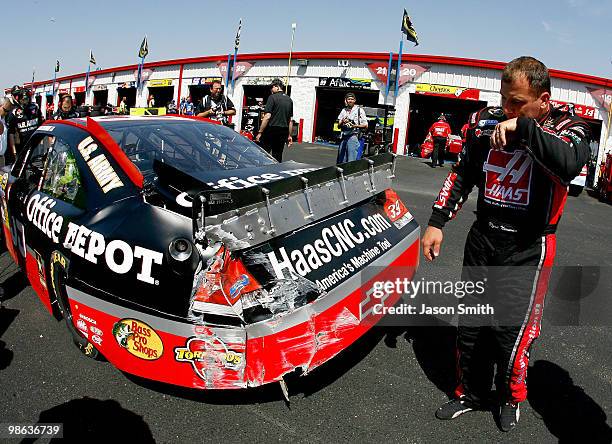 Ryan Newman stands next to the wreaked Haas Automation/Office Depot Chevrolet, in the garage area after an incident on track during practice for the...