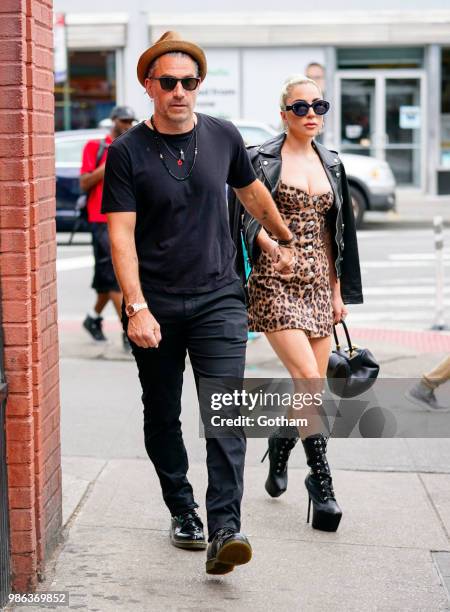 Lady Gaga and Christian Carino walk to her studio on June 28, 2018 in New York City.