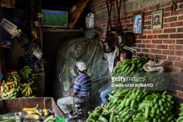 People watch the World Cup match between Colombia and Senegal on TV at a popular market in Cali, Colombia, on June 28, 2018. Colombia beat Senegal...