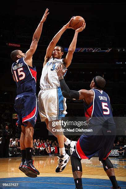 JaVale McGee of the Washington Wizards goes up for a shot against Al Horford and Josh Smith of the Atlanta Hawks during the game at the Verizon...