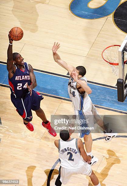 Marvin Williams of the Atlanta Hawks goes up for a shot against Shaun Livingston and JaVale McGee of the Washington Wizards during the game at the...