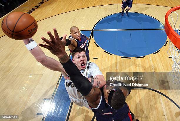 Mike Miller of the Washington Wizards goes up for a shot against Josh Smith and Maurice Evans of the Atlanta Hawks during the game at the Verizon...