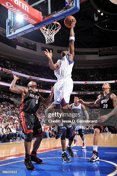 Jodie Meeks of the Philadelphia 76ers shoots a layup against Quentin Richardson and Michael Beasley of the Miami Heat during the game at Wachovia...