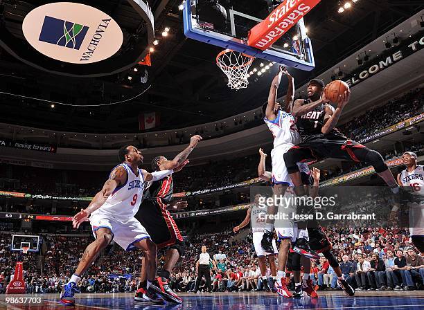 Dorell Wright of the Miami Heat looks to pass against Louis Williams and Andre Iguodala of the Philadelphia 76ers during the game at Wachovia Center...