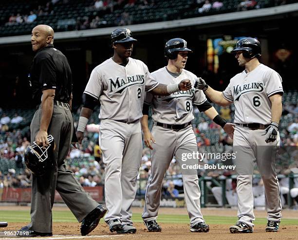 Hanley Ramirez, Chris Coughlan and Dan Uggla of the Florida Marlins score in the first inning against the Houston Astros on a fielding error by...