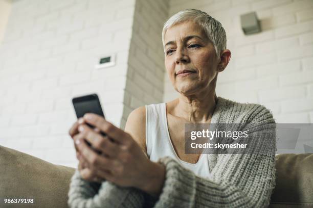 below view of a mature woman using cell phone. - 2017 common good forum stock pictures, royalty-free photos & images