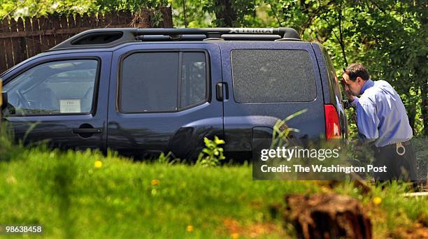 An unidentified officer looks into the car belonging to murdered Shaw Middle School principal Brian Betts that was recovered in southeast Washington,...