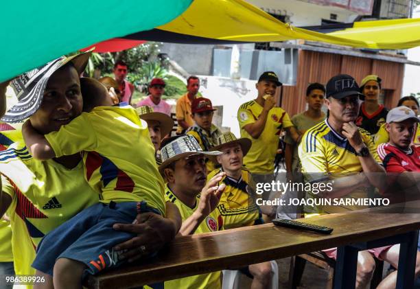 People watch the World Cup match between Colombia and Senegal on TV at the Comuna Popular 1 in Medellin, Colombia, on June 28, 2018. - Colombia beat...