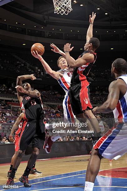 Jonas Jerebko of the Detroit Pistons goes up for a shot against Amir Johnson and DeMar DeRozan of the Toronto Raptors during the game at the Palace...