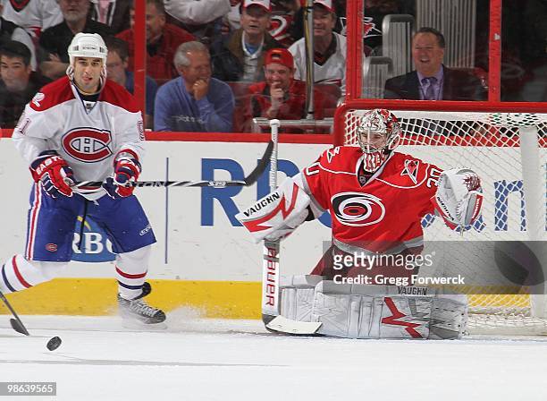 Cam Ward of the Carolina Hurricanes prepares to make a save behind Scott Gomez of the Montreal Canadiens during a NHL game on April 8, 2010 at RBC...