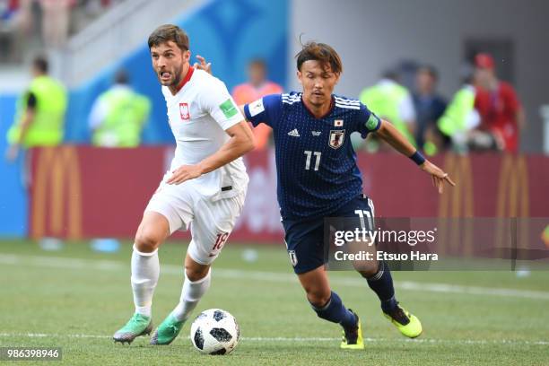 Takashi Usami of Japan and Bartosz Bereszynski of Poland compete for the ball during the 2018 FIFA World Cup Russia group H match between Japan and...