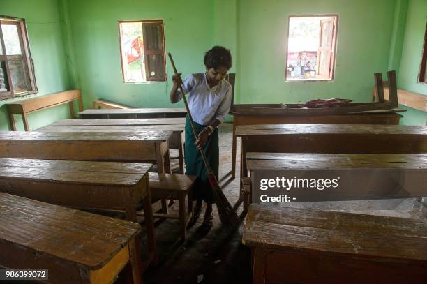 An ethnic Rakhine school girl cleans classroom at Inn Din village in Rakhine state on 28 June 2018. - More than 700,000 Rohingya Muslims were forced...