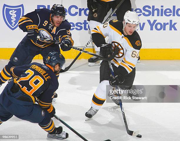 Vladimir Sobotka of the Boston Bruins tries to skate away from Jason Pominville and Derek Roy of the Buffalo Sabres in Game Five of the Eastern...