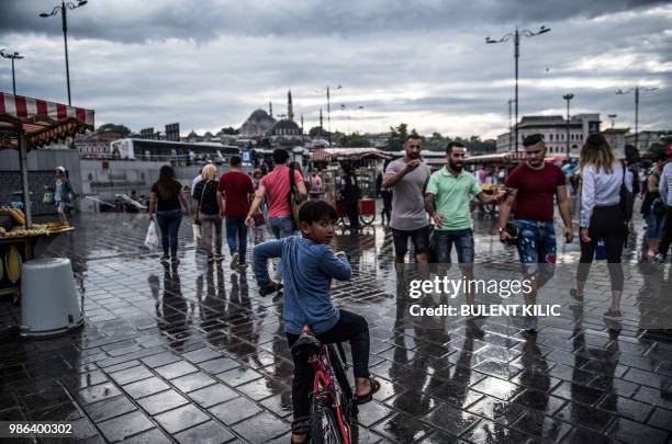 People walk on Eminonu Square, in Istanbul, on June 28, 2018.