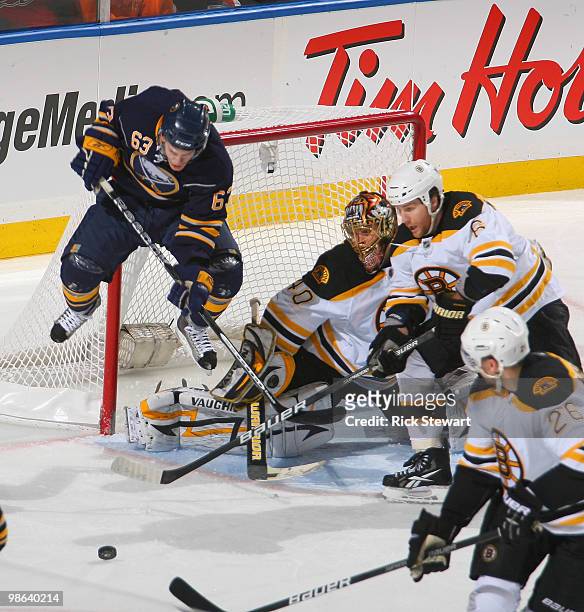 Tyler Ennis of the Buffalo Sabres jumps to allow the puck to com to the net as Tuukka Rask, Dennis Wideman and Blake Wheeler of the Boston Bruins...