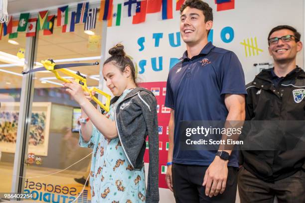 Cody Radziewicz of the Dallas Rattlers plays Battleship Archery with Giselle at Boston Children's Hospital on June 28, 2018 in Boston, Massachusetts.