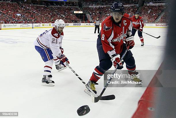 Alex Ovechkin of the Washington Capitals plays the puck against Brian Gionta of the Montreal Canadiens in Game Five of the Eastern Conference...