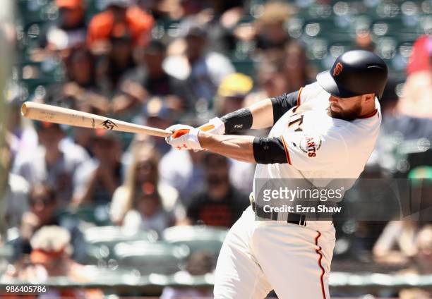 Brandon Belt of the San Francisco Giants hits a two-run home run against the Colorado Rockies in the first inning at AT&T Park on June 28, 2018 in...