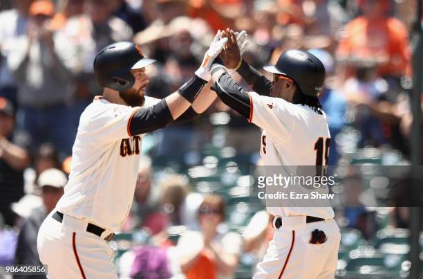 Brandon Belt of the San Francisco Giants is congratulated by Alen Hanson after he hit a two-run home run against the Colorado Rockies in the first...