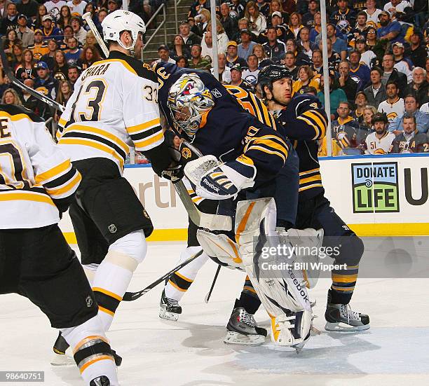Ryan Miller of the Buffalo Sabres defends his net while being bumped by Zdeno Chara of the Boston Bruins in Game Five of the Eastern Conference...