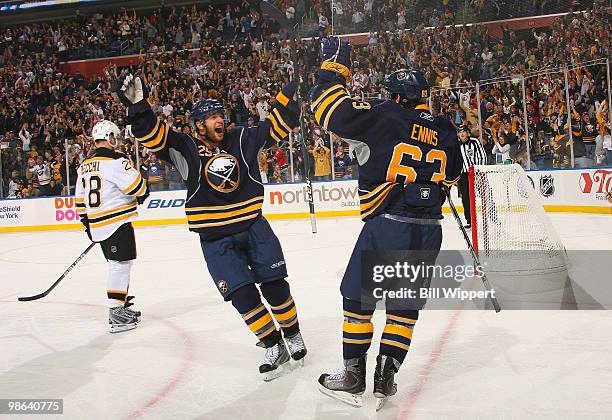 Tyler Ennis of the Buffalo Sabres celebrates his third period empty net goal with teammate Jason Pominville in front of Mark Recchi of the Boston...