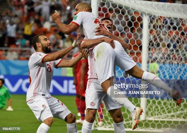 Tunisia's forward Wahbi Khazri is congratulated by teammates after scoring a goal during the Russia 2018 World Cup Group G football match between...