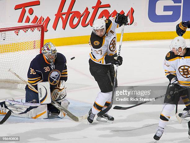 Ryan Miller of the Buffalo Sabres makes a save as Patrice Bergeron of the Boston Bruins avoids the puck in Game Five of the Eastern Conference...