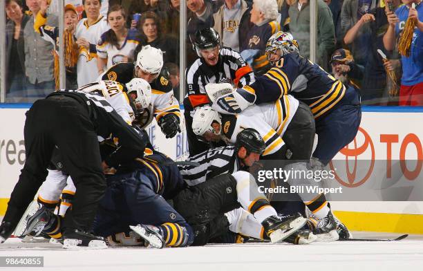 Goaltender Ryan Miller of the Buffalo Sabres grabs hold of Miroslav Satan of the Boston Bruins in front of referee Dan O'Rourke during an altercation...