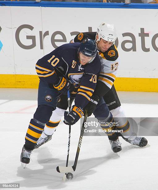Henrik Tallinder of the Buffalo Sabres and Milan Lucic of the Boston Bruins fight for puck control in Game Five of the Eastern Conference...