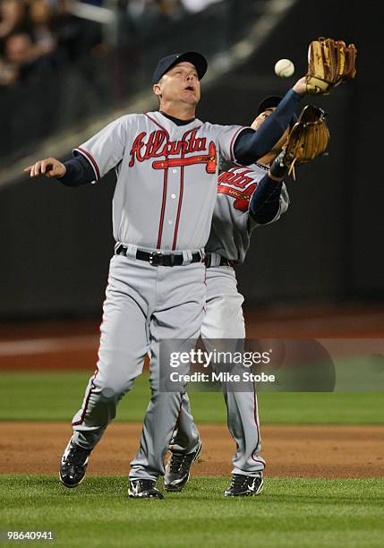 Chipper Jones and Omar Infante of the Atlanta Braves collide and drop a fly ball against the New York Mets on April 23, 2010 at Citi Field in the...