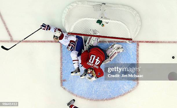 Travis Moen of the Montreal Canadiens crashes into Semyon Varlamov of the Washington Capitals in Game Five of the Eastern Conference Quarterfinals...