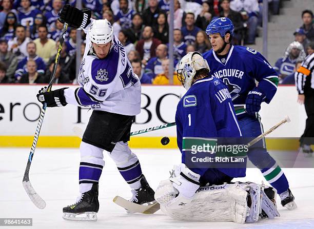 Goalie Roberto Luongo of the Vancouver Canucks stops Richard Clune of the Los Angeles Kings deflection while Kevin Bieksa of the Canucks look on...