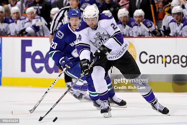 Alexander Frolov of the Los Angeles Kings tries to gain control of a bouncing puck while being pursued by Alexander Edler of the Vancouver Canucks...