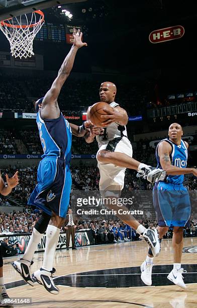 Richard Jefferson of the San Antonio Spurs jumps to pass around Erick Dampier of the Dallas Mavericks in Game Three of the Western Conference...