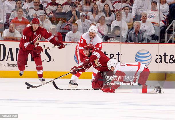 Lee Stempniak of the Phoenix Coyotes clears the puck around Dan Cleary and Andreas Lilja of the Detroit Red Wings in Game Five of the Western...
