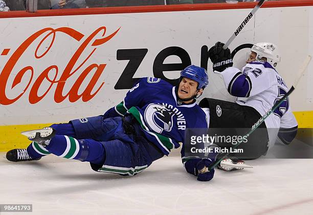 Kevin Bieksa of the Vancouver Canucks reacts as he falls to the ice after colliding with Jeff Halpern of the Los Angeles Kings during the second...