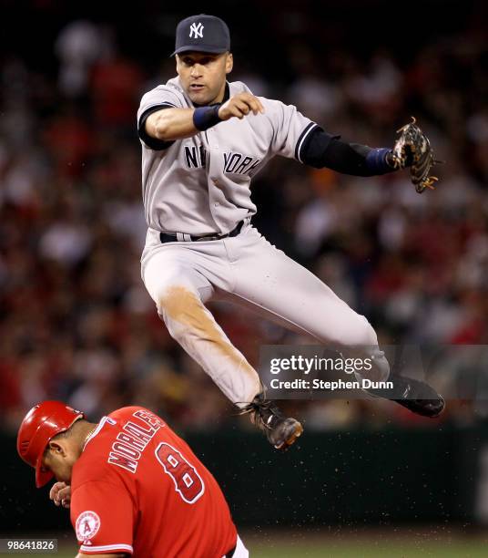 Shortstop Derek Jeter of the New York Yankees throws to first after forcing out Kendry Morales of the Los Angeles Angels of Anaheim to turn a double...