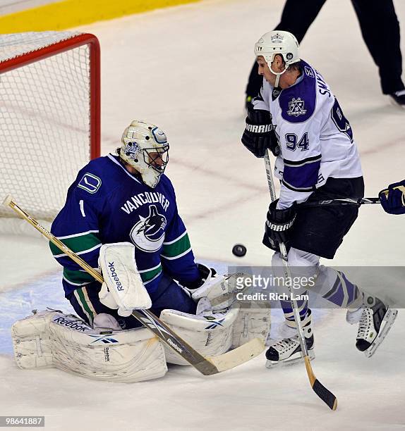 Goalie Roberto Luongo of the Vancouver Canucks redirects the puck after make a save while Ryan Smyth of the Los Angeles Kings looks for a rebound...