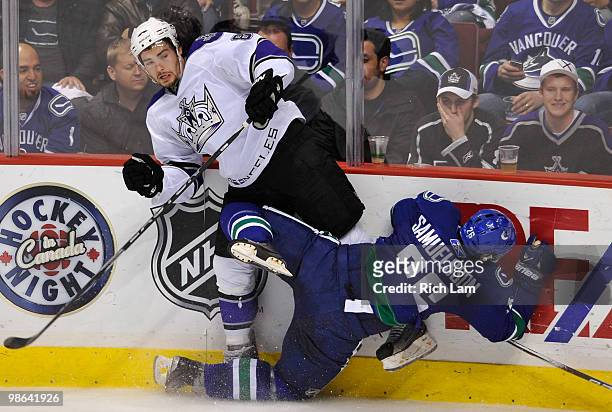 Mikael Samuelsson of the Vancouver Canucks falls to the ice after colliding with Drew Doughty of the Los Angeles Kings during the second period in...