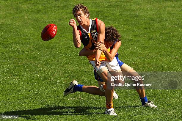 Matthew Buntine of the Stingrays handballs whilst being tackled during the round four TAC Cup match between the Eastern Ranges and Dandenong...