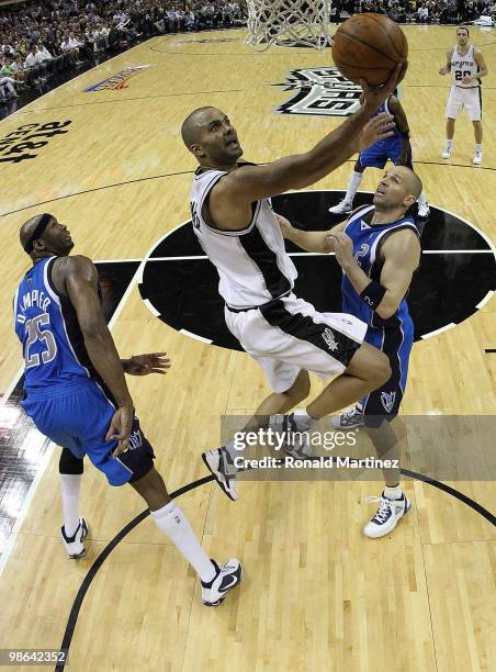 Guard Tony Parker of the San Antonio Spurs takes a shot against Jason Kidd and Erick Dampier of the Dallas Mavericks in Game Three of the Western...