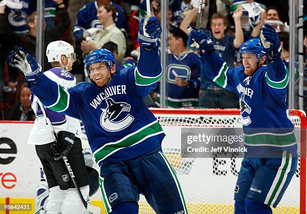 Jeff Halpern of the Los Angeles Kings skates away dejected as Mikael Samuelsson and Henrik Sedin of the Vancouver Canucks celebrate a goal in Game...
