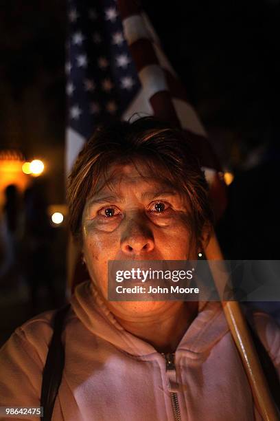 Julia Martinez, a Mexican citizen working for 19 years in the United States as a nanny with a work visa, carries an American flag while protesting...