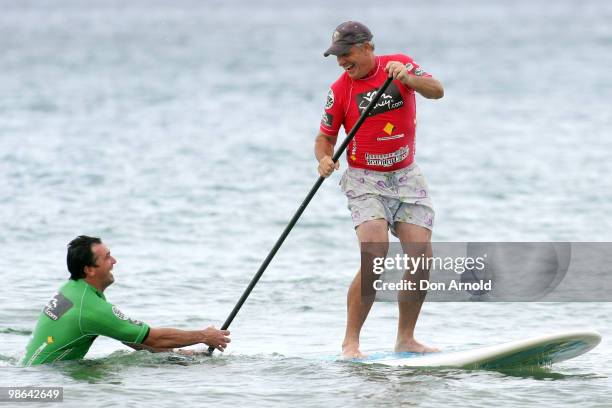 Ian 'Dicko' Dickson gets a friendly shove from Shannon Noll as he competes in the paddle-board competition during the Beachley Classic Celebrity...