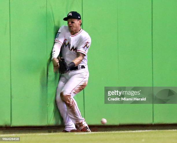 Florida Marlins outfielder Derek Dietrich hits the wall trying to catch a ball in the third inning against the Arizona Diamondbacks at Marlins Park...