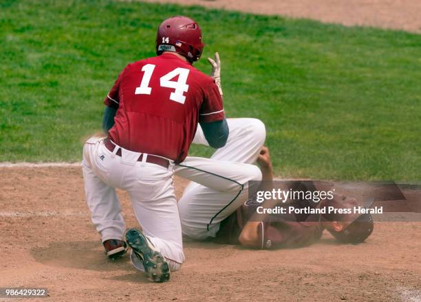 Gorham pitcher Jacob Sladen holds his chest after being hit in a head-first slide by Zach Murray of Bangor during the Class A state baseball...