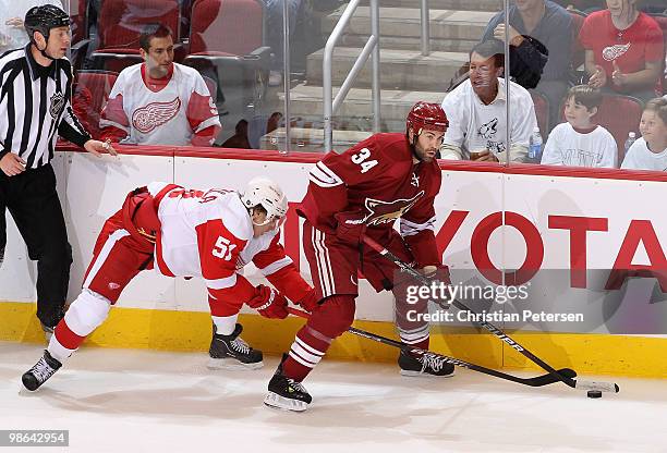 Daniel Winnik of the Phoenix Coyotes looks to pass the puck under pressure from Valtteri Filppula of the Detroit Red Wings in Game Five of the...