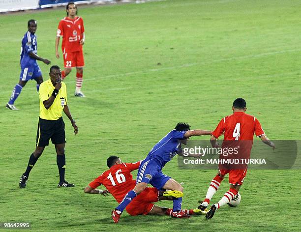 Marwan Mabrouk and Walid al-Shteroci of Libya's Al-Ittihad football team fight for the ball with an unidentified player from Egypt's Al-Ahly club...